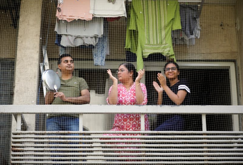 Residents clap and bang utensils from their balcony to cheer for emergency personnel and sanitation workers who are on the frontlines in the fight against coronavirus, in Ahmedabad