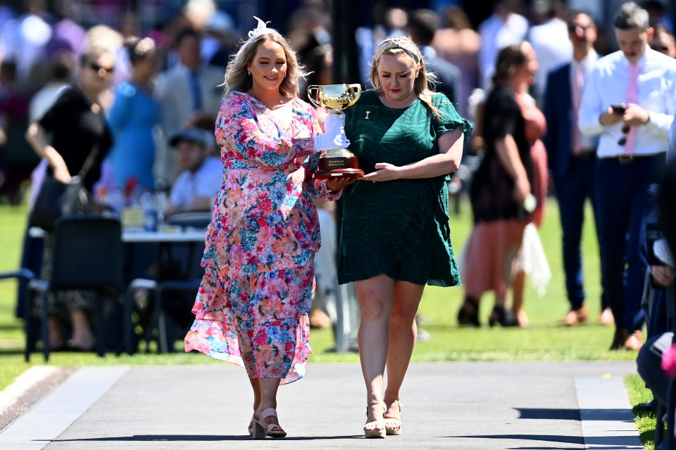 Frontline workers carry the Melbourne Cup during 2021 Melbourne Cup Day at Flemington