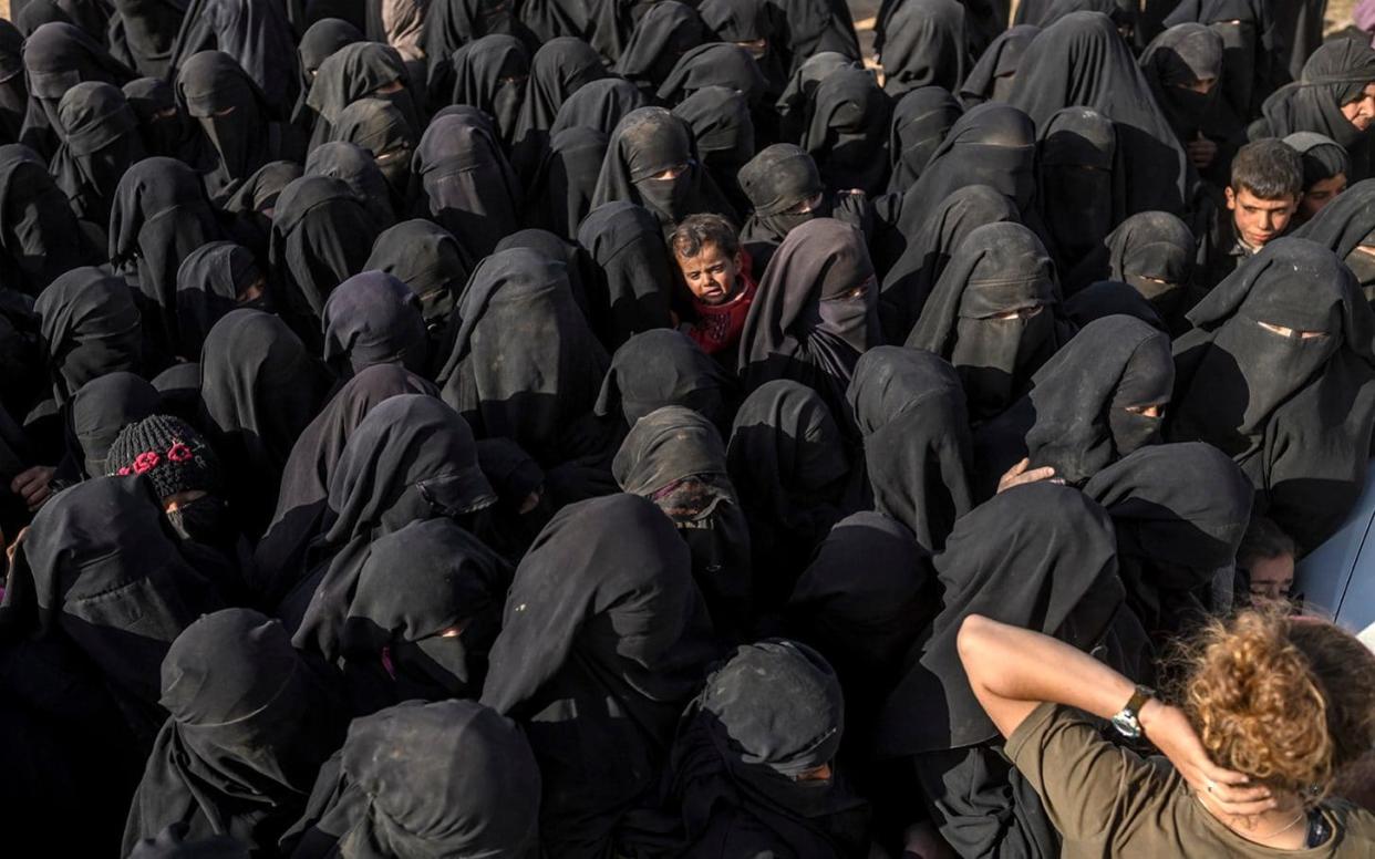 Civilians evacuated from the Isil group's embattled holdout of Baghouz wait at a screening area held by SDF, in the eastern Syrian province of Deir Ezzor - AFP