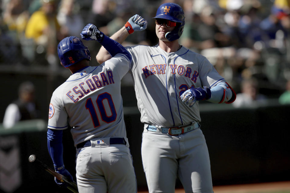 New York Mets designated hitter Pete Alonso (20) is congratulated by New York Mets Eduardo Escobar (10) after hitting a home run in the fourth inning of a baseball game against the Oakland Athletics in Oakland, Calif., on Sunday, Sept. 25, 2022. (AP Photo/Scot Tucker)