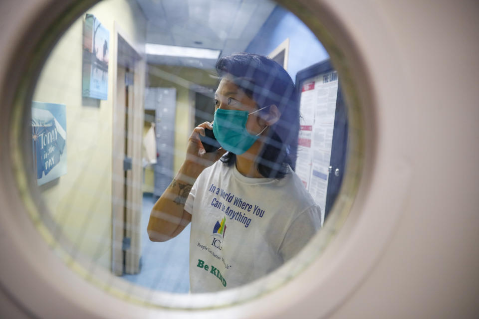 Dr. Jeanie Tse, chief medical officer at the Institute for Community Living, calls ahead to a patient while she stops to administer medications at the Lawton Residences during her rounds, Wednesday, May 6, 2020, in the Brooklyn borough of New York. (AP Photo/John Minchillo)