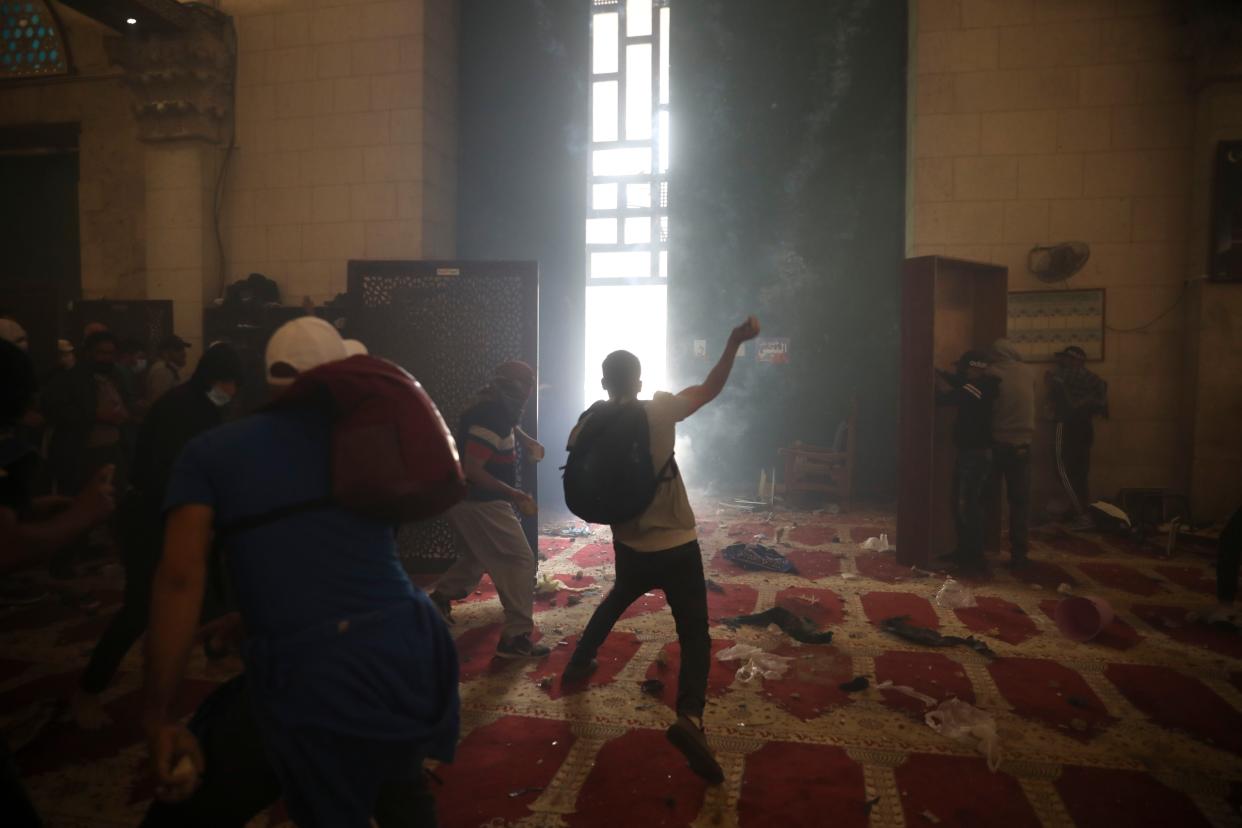 Palestinians inside the mosque clash with Israeli security forces at the Al-Aqsa Mosque compound in Jerusalem's Old City on Monday, May 10, 2021. Israeli police clashed with Palestinian protesters at a flashpoint Jerusalem holy site on Monday, the latest in a series of confrontations that are pushing the contested city to the brink of eruption. Palestinian medics said at least 180 Palestinians were hurt in the violence at the Al-Aqsa Mosque compound, including 80 who were hospitalized.