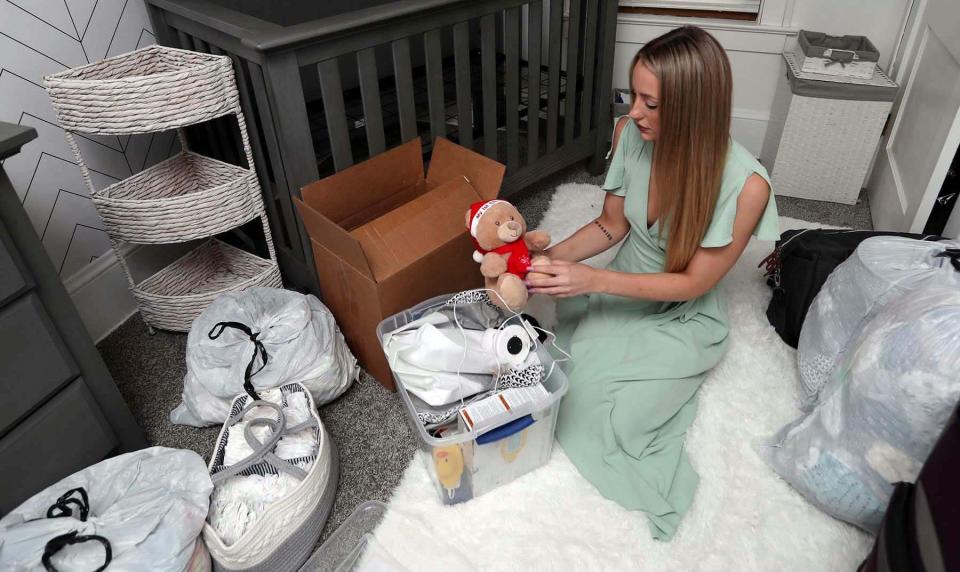 Breanne Paquin of Akron, Ohio holds a teddy bear in the nursery she set up after connecting with an expectant mother on social media. The nursery remains empty after Paquin says she was scammed out of nearly $9,000.
