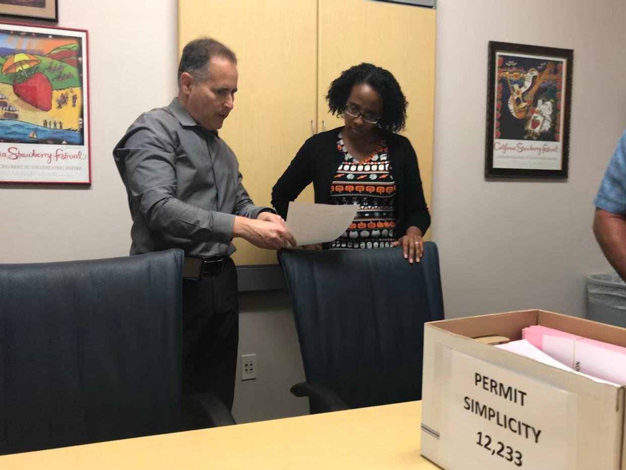 Aaron Starr, left, speaks to then-Oxnard City Clerk Michelle Ascencion in October 2019 when he submitted tens of thousands of signatures in support of five ballot initiatives, including an initiative for term limits for some elected officials. A judge recently ordered the city to place the term limit initiative on the Nov. 8 ballot.