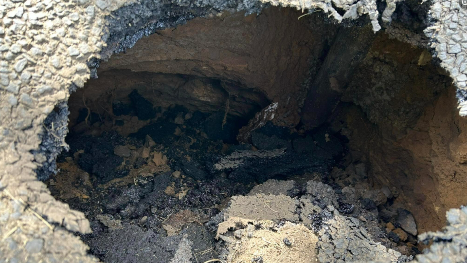 A close up view of the sinkhole showing a hole about two-feet deep