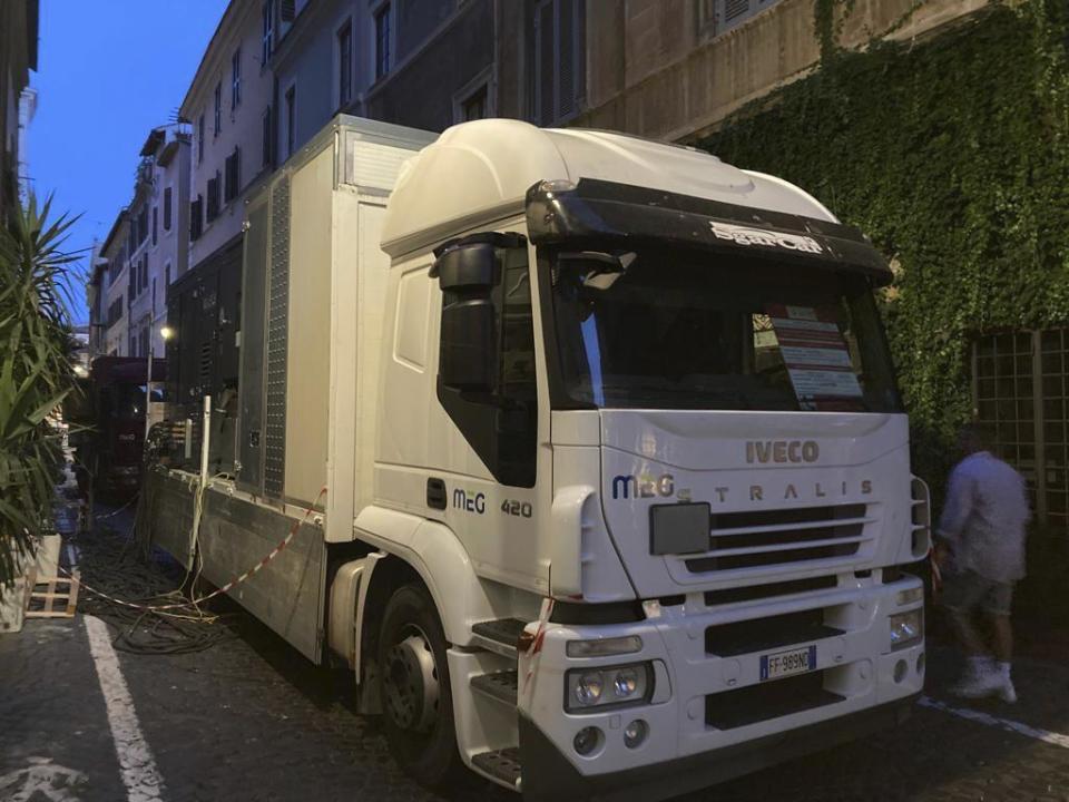 A truck of generators rented to provide power to a central Roman neighborhood hit by a localized blackout blocks the doors of stores forcing them to shut down for a week, Tuesday, July 25, 2023. Rising global temperatures are elevating air conditioning from a luxury to a necessity in many parts of Europe, which long has had a conflictual relationship with energy-sucking cooling systems deemed by many a U.S. indulgence. (AP Photo/Nicole Winfield)