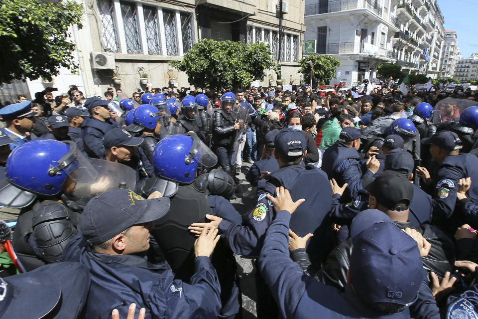Algerian police forces face students demonstrating in Algiers, Tuesday, April 9, 2019. Algerian police have fired tear gas and water cannon to break up a group of students protesting in the country's capital, less than an hour after the country's parliament chose an interim leader. (AP Photo/Anis Belghoul)