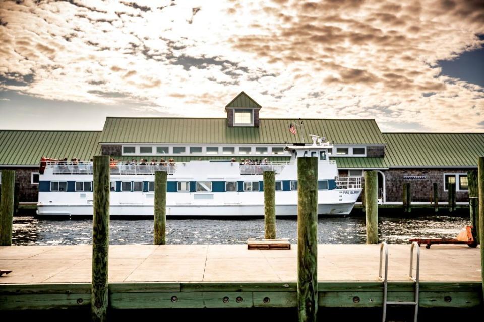 a fire island ferry filled with passengers as seen from dock