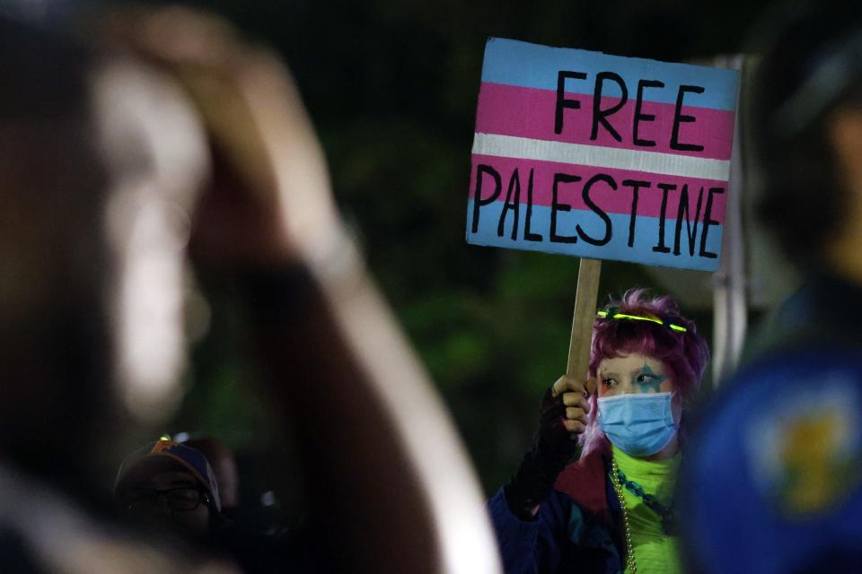 A protester holds up a sign outside of the Phillips Center for the Performing Arts after Ben Shapiro spoke about the Israel-Hamas war in Gainesville, Fla., Wednesday, Oct. 18, 2023.