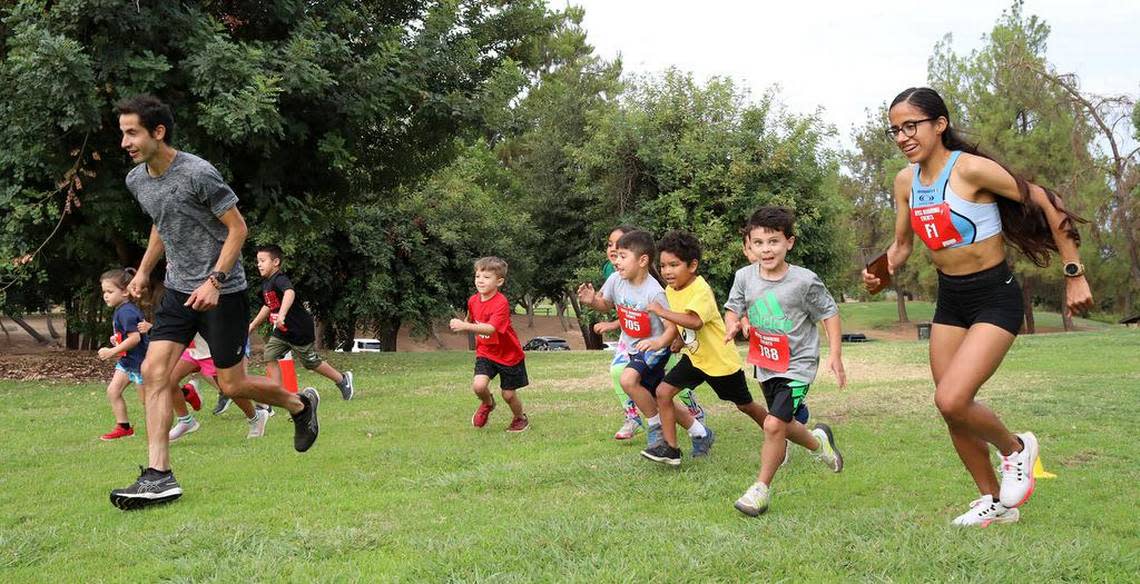 Diego Estrada and Daniela Torres direct the children's run at the Miguel Reyes 5k at Woodward Park on July 31, 2022.