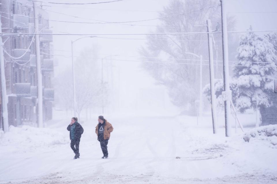 Residents walk down the street to their homes Tuesday, Jan. 9, 2024, in Des Moines.