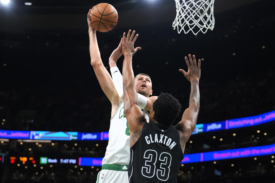 Boston Celtics center Kristaps Porzingis (8) takes a shot over Brooklyn Nets center Nic Claxton (33) during the first half of an NBA basketball game, Wednesday, Feb. 14, 2024, in Boston. (AP Photo/Charles Krupa)