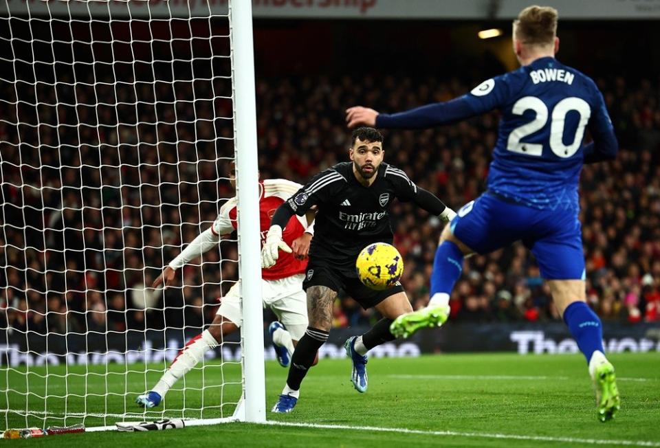 West Ham United's Jarrod Bowen (R) fights for the ball with Arsenal's David Raya (C) during the English Premier League football match between Arsenal and West Ham at the Emirates Stadium in London on December 28, 2023. (Photo by HENRY NICHOLLS/AFP via Getty Images)