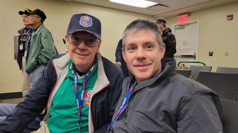 Enka High School wrestling coach Mark Harris, right, poses with his father, Charles, on April 27 at Asheville Regional Airport prior to the Blue Ridge Honor Flight to Washington, D.C. Harris and his father went as Gold Star Family members, honoring Bruce Harris.