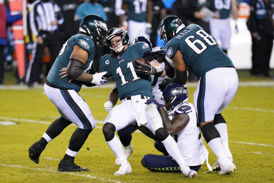 Philadelphia Eagles' Carson Wentz (11) is sacked by Seattle Seahawks' Benson Mayowa (95) during the second half of an NFL football game, Monday, Nov. 30, 2020, in Philadelphia. (AP Photo/Chris Szagola)