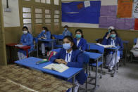 Students wearing face masks to prevent the spread of the coronavirus attend their class at a school, in Lahore, Pakistan, Monday, Jan. 18, 2021. Pakistani authorities started to reopen schools in phases despite a steady increase in deaths and infections from the coronavirus, official said. (AP Photo/K.M.Chaudary)