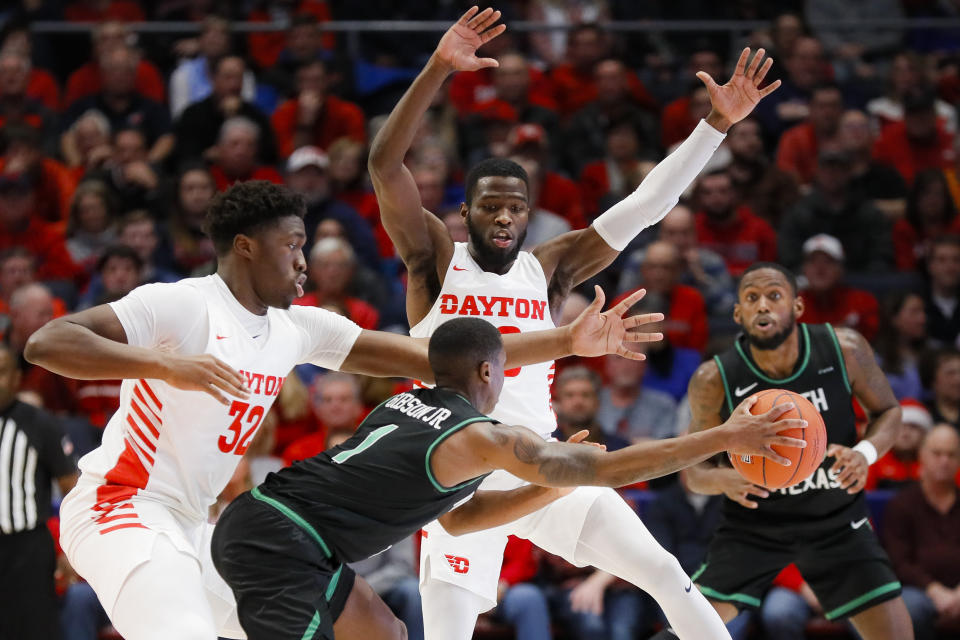 North Texas' Umoja Gibson (1) attempts a pass against Dayton's Jordy Tshimanga (32) and Jalen Crutcher, above, during the first half of an NCAA college basketball game, Tuesday, Dec. 17, 2019, in Dayton, Ohio. (AP Photo/John Minchillo)