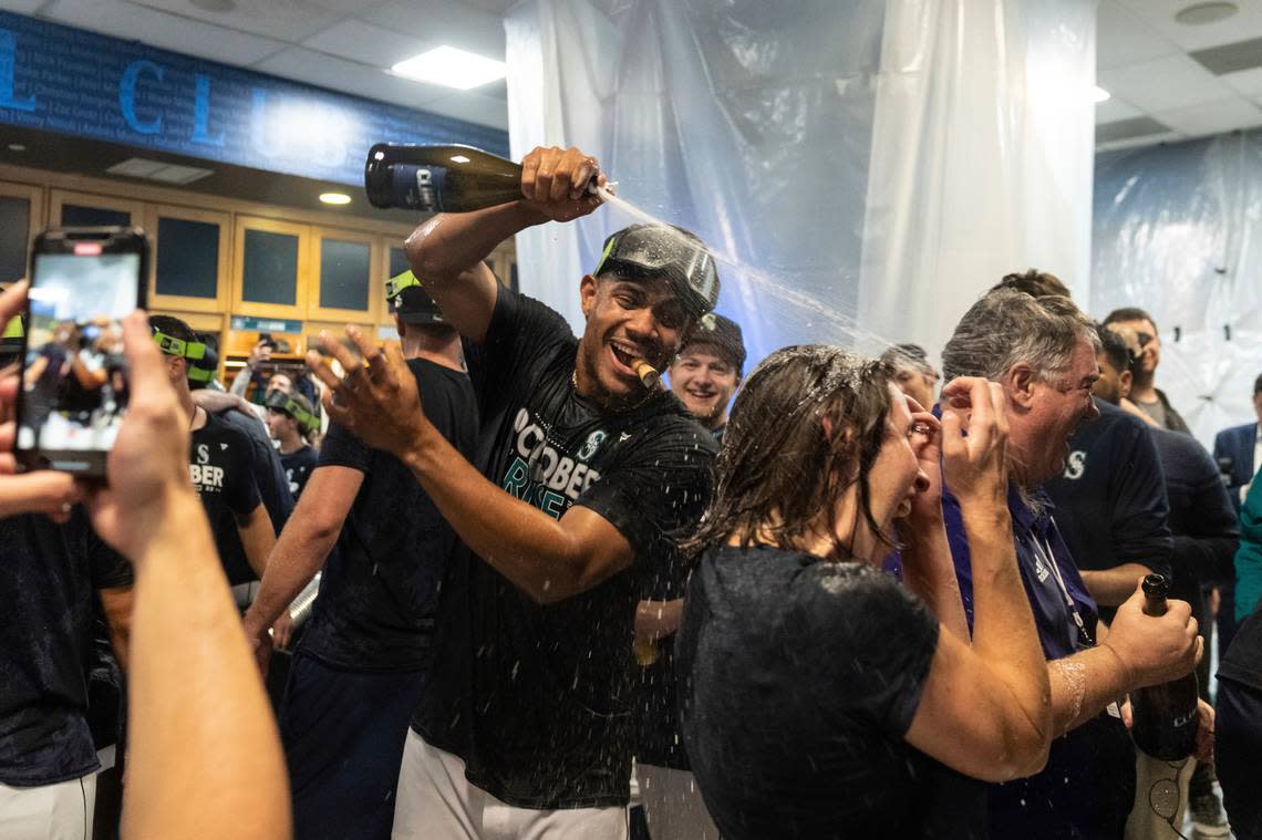 Seattle Mariners’ Julio Rodriguez and teammates celebrates in the clubhouse after a baseball game against the Oakland Athletics, Friday, Sept. 30, 2022, in Seattle. The Mariners won 2-1 to clinch a spot in the playoffs. (AP Photo/Stephen Brashear)