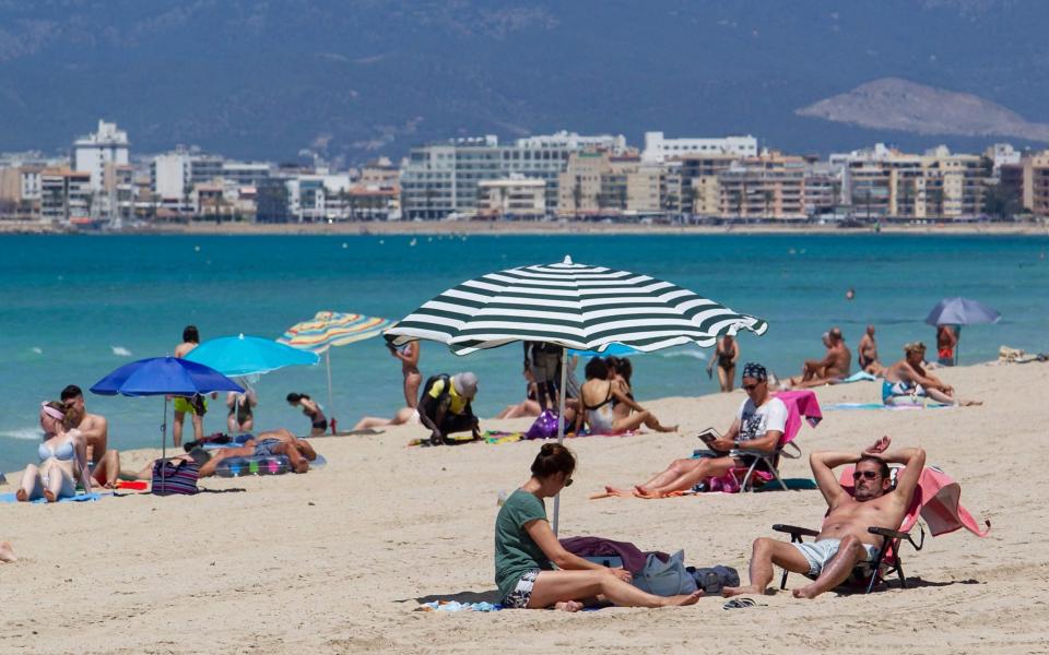 Tourists sunbathe at Palma Beach in Palma de Mallorca - JAIME REINA/AFP