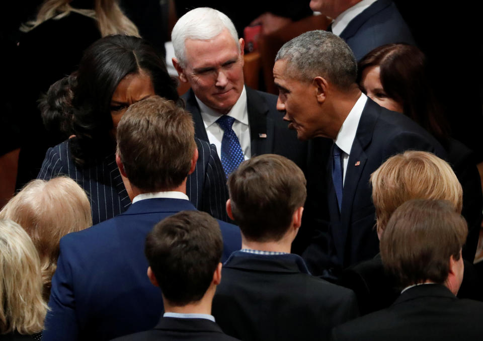 Vice President Mike Pence listens to Barack Obama as they gather prior to the state funeral for former Bush.&nbsp;