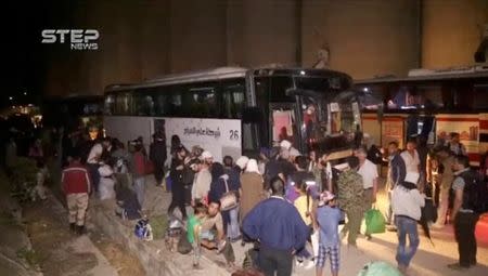 A still image taken from a video posted to a social media website said to be shot on May 15, 2017, shows people gathering near buses in what is said to be Qalaat al-Madiq, Hama province, Syria. Social Media Website via Reuters TV