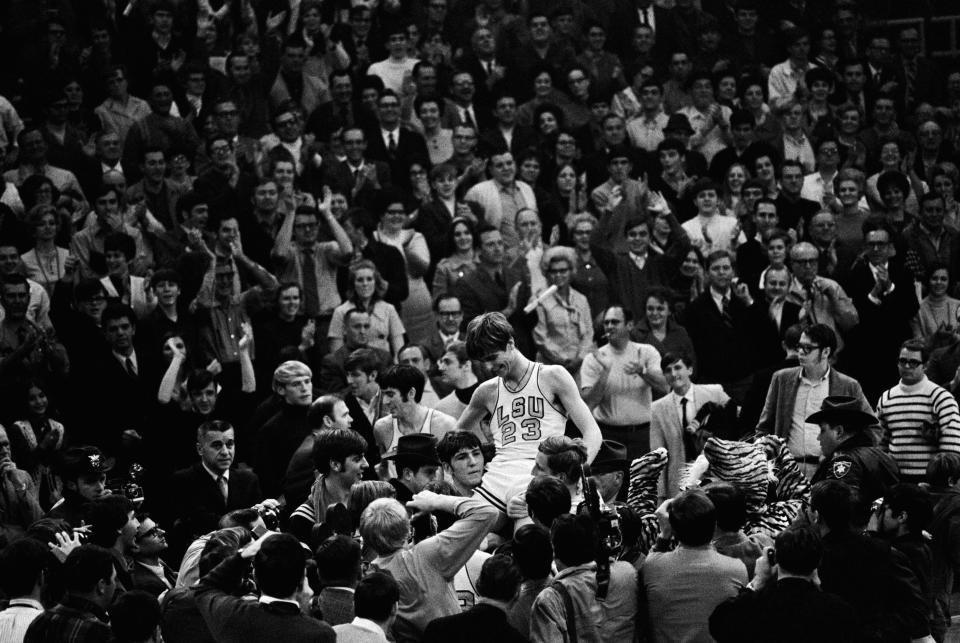 Pistol Pete Maravich (23) gets a boost from players and fans after he broke the all-time scoring record in Baton Rouge Saturday night, Jan. 28, 1979. Calmly looking on at far left center is Pete's dad, Press, who coaches the Louisiana State Tigers. (AP Photo)