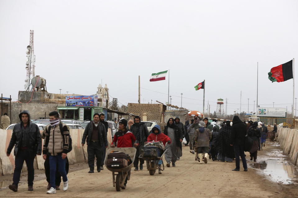 FILE- In this Feb. 20, 2019 file photo, Afghans return to Afghanistan at the Islam Qala border with Iran, in the western Herat Province. Taliban have taken control of Islam Qala crossing border in western Herat province at the neighboring Iran, an Afghan official and Iranian media confirmed on Thursday, July 8, 2021. (AP Photo/Rahmat Gul, File)