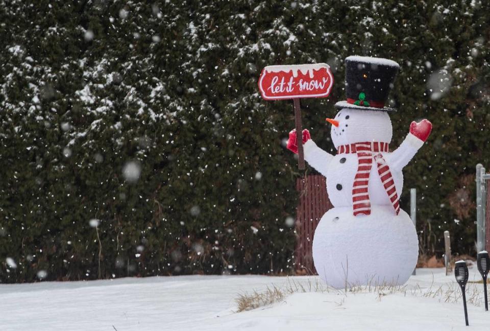 Large flakes fall, covering a yard ornament in Richland with a fresh blanket of snow.