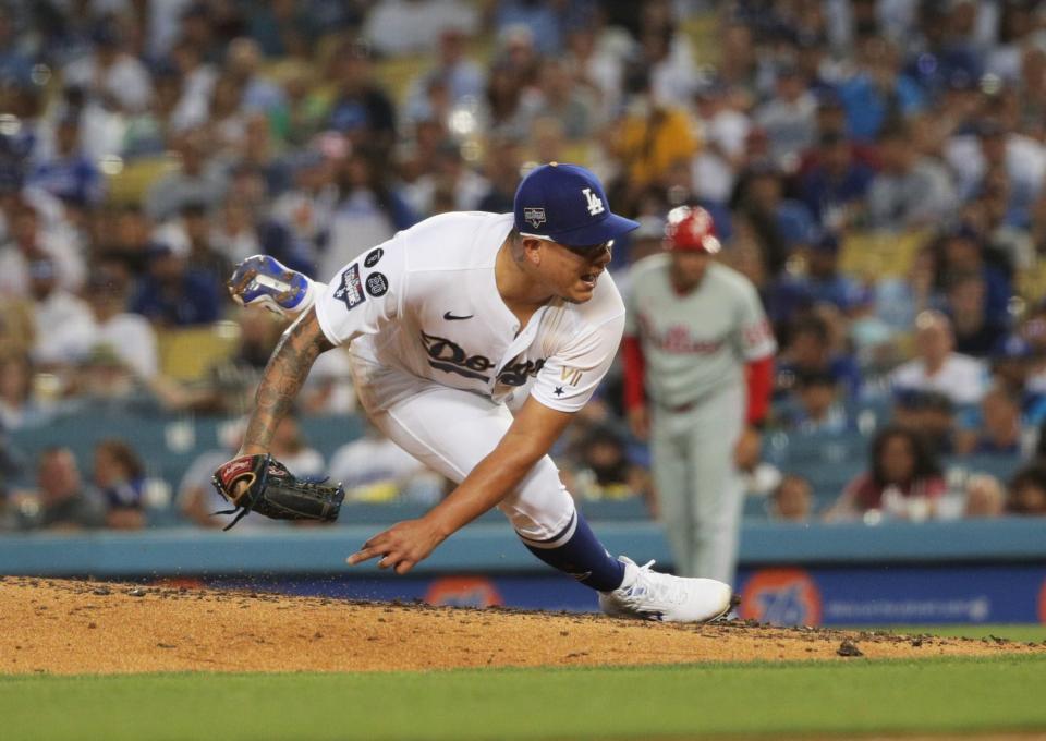 Dodgers starting pitcher Julio Urias slips on the mound while pitching.