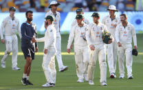 India's Cheteshwar Pujara, second left, is congratulated by Australia's Matthew Wade after defeating Australia by three wickets on the final day of the fourth cricket test at the Gabba, Brisbane, Australia, Tuesday, Jan. 19, 2021.India won the four test series 2-1. (AP Photo/Tertius Pickard)