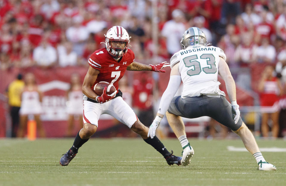 Sep 11, 2021; Madison, Wisconsin, USA; Wisconsin Badgers wide receiver Danny Davis III (7) rushes with the football after catching a pass as Eastern Michigan Eagles linebacker Matthew Buschman (53) defends during the first quarter at Camp Randall Stadium. Mandatory Credit: Jeff Hanisch-USA TODAY Sports