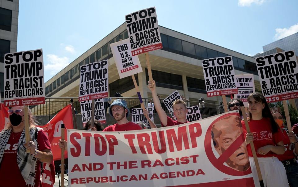 Demonstrators hold a "Stop Trump" sign
