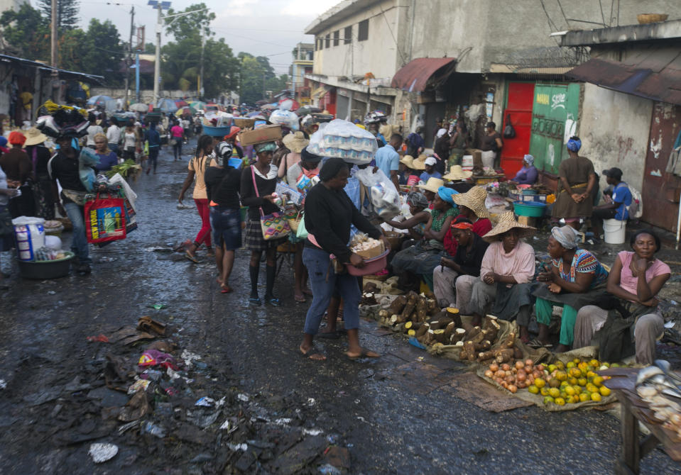 In this Dec. 4, 2019 photo, street vendors sell their produce in Petion-Ville, Haiti. A growing number of families across Haiti can't afford to buy food since protests began in Sept., with barricades preventing the flow of goods between the capital and the rest of the country. (AP Photo/Dieu Nalio Chery)