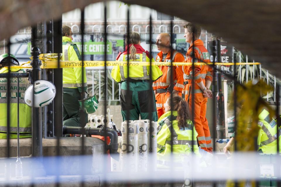 <p>Emergency service responders stand close to the scene (PA Images) </p>
