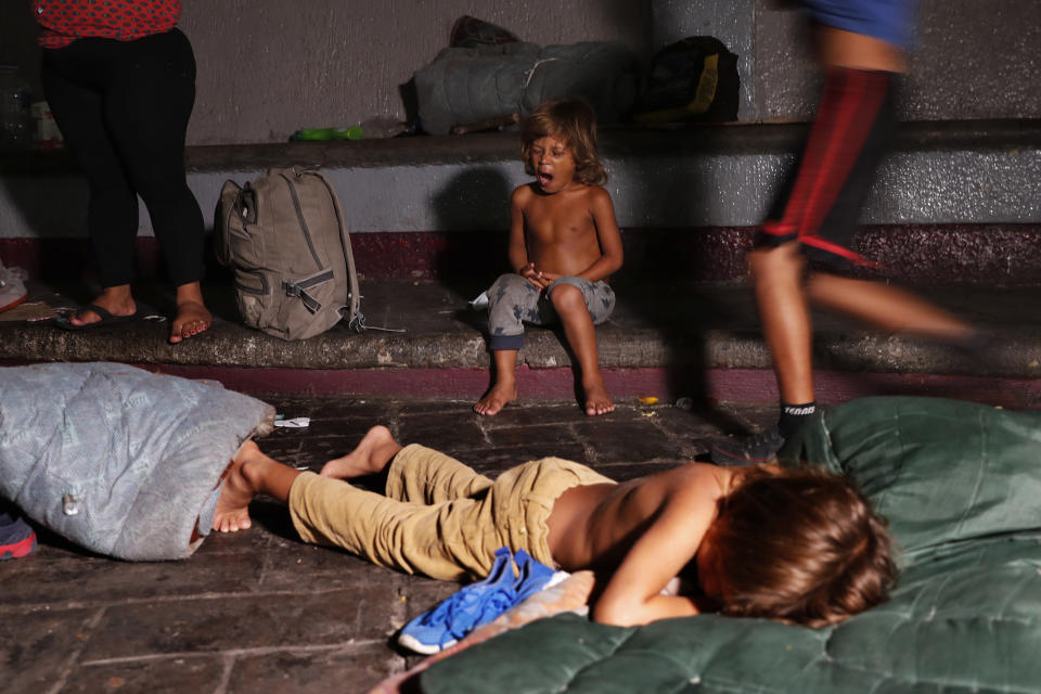 CORRECTS DAY AND DATE - A child yawns after he is woken from his sleep by Mexican immigration authorities who arrived to push out camping migrant families from a park in Tapachula, Mexico, late Tuesday, May 28, 2019. Authorities cleared the park of camping Central American migrants and the makeshift encampment of Haitians and African migrants outside the immigration detention center near the Guatemala border. (AP Photo/Marco Ugarte)