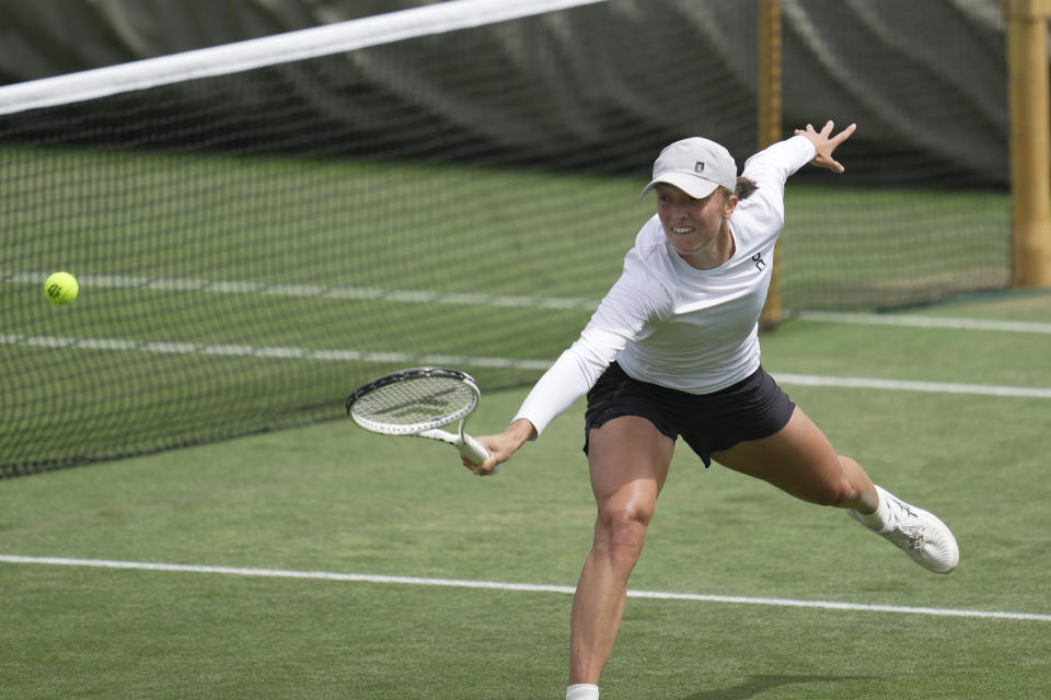 Iga Swiatek of Poland takes part in a practice session ahead of the Wimbledon tennis championships at Wimbledon, in London, Sunday, July 2, 2023. The Wimbledon Tennis championships start on July 3. (AP Photo/Kin Cheung)