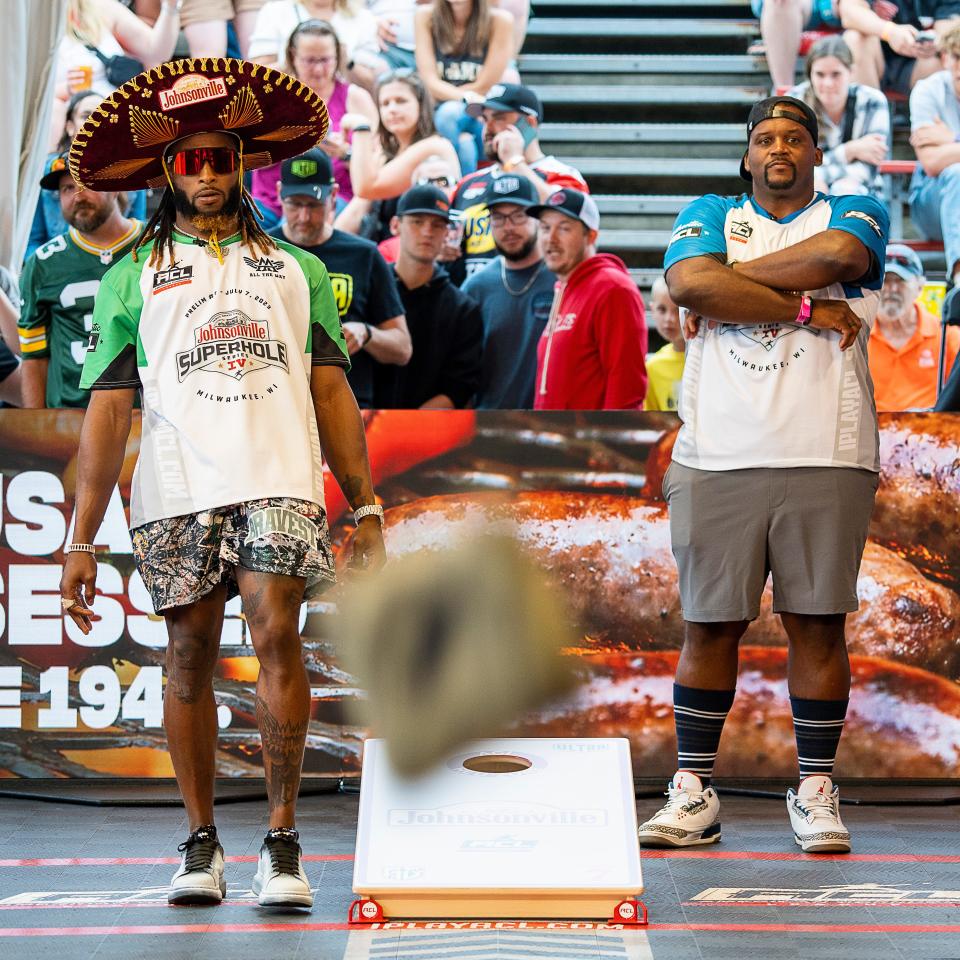 (Left) Packers running back Aaron Jones and (right) former Chicago Bears Spice Adams compete in the Superhole Cornhole at the Gruber Law Offices Sportszone on Friday, July 7, 2023.