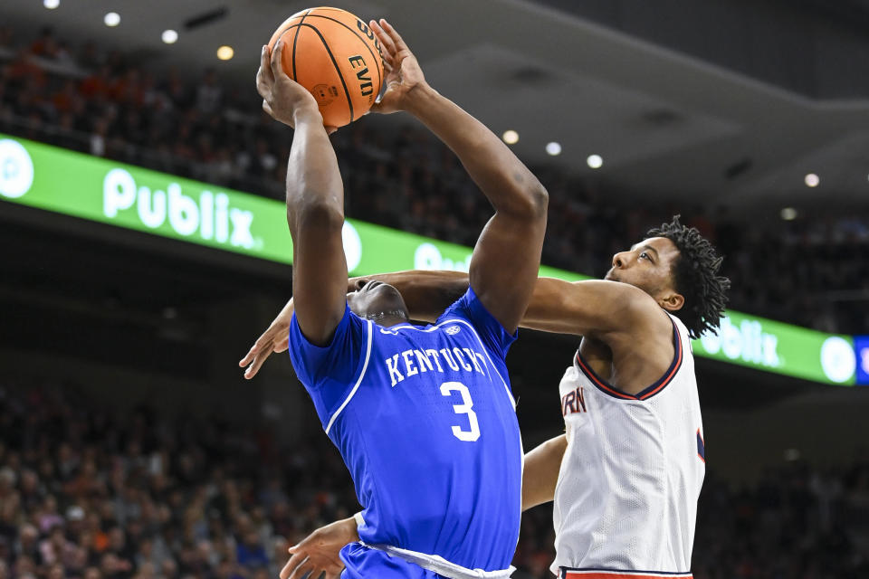 Auburn forward Chaney Johnson (31) fouls Kentucky guard Adou Thiero (3) during the first half of an NCAA college basketball game Saturday, Feb. 17, 2024, in Auburn, Ala. (AP Photo/Julie Bennett)