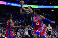 Brooklyn Nets' Kevin Durant (7) goes up for a shot between Philadelphia 76ers' Matisse Thybulle (22) and Tyrese Maxey (0) during the first half of an NBA basketball game, Friday, Oct. 22, 2021, in Philadelphia. (AP Photo/Matt Slocum)