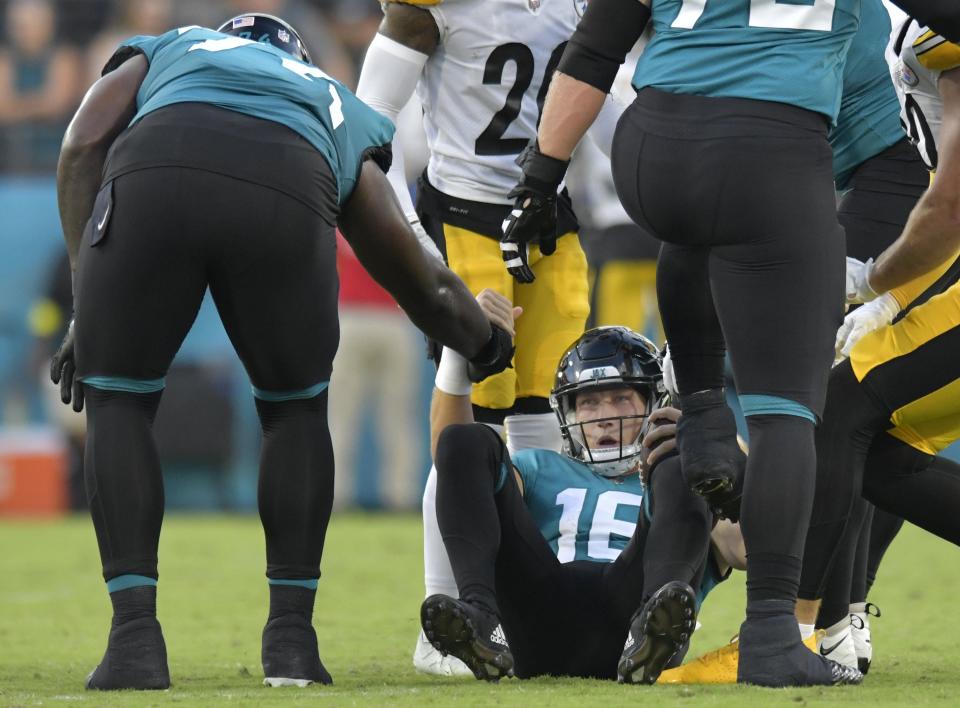 Jacksonville Jaguars offensive tackle Cam Robinson (74) gives quarterback Trevor Lawrence (16) a hand up after a late first quarter sack. The Jacksonville Jaguars hosted the Pittsburgh Steelers in pre-season football at TIAA Bank Field in Jacksonville, FL Saturday, August 20, 2022. The Steelers led at the half 7-6. [Bob Self/Florida Times-Union]