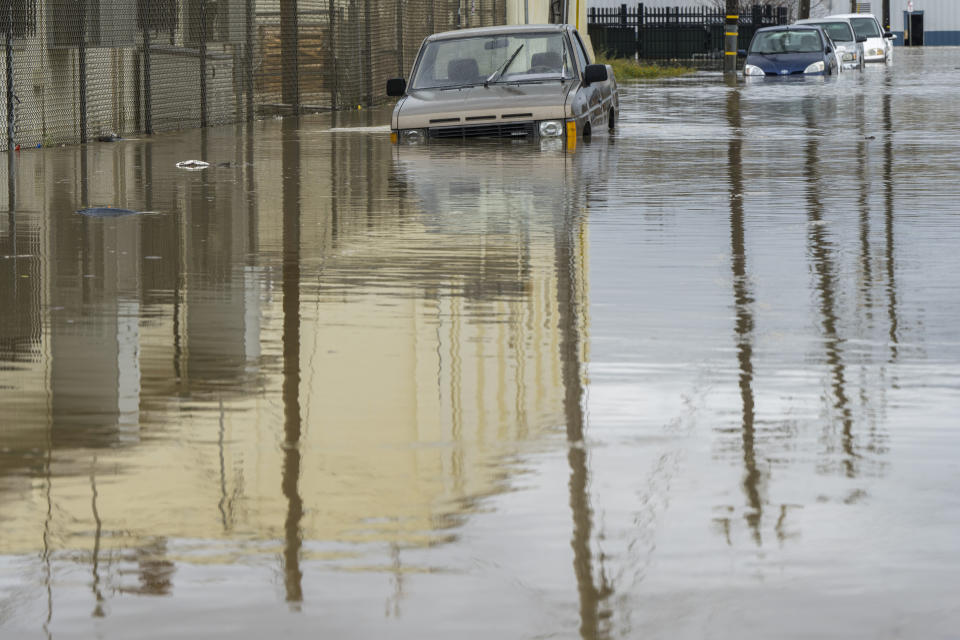 Cars are partially submerged in floodwaters in Watsonville, Calif., Saturday, March 11, 2023. (AP Photo/Nic Coury)