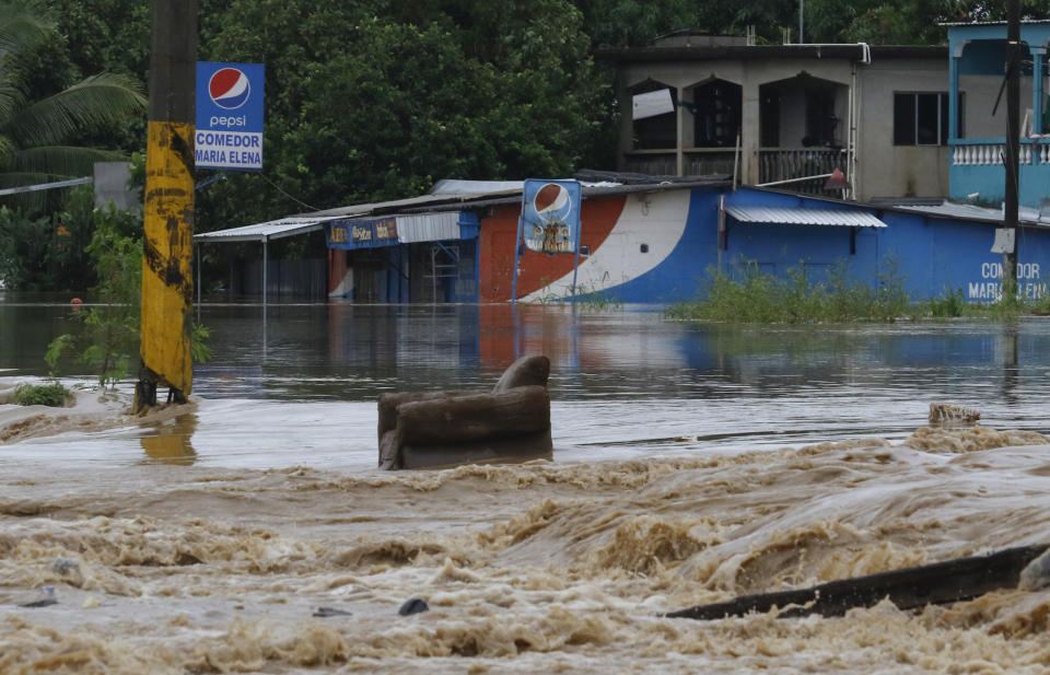 A chair sits in a flooded road after the passing of Iota in La Lima, Honduras, Wednesday, Nov. 18, 2020. Iota flooded stretches of Honduras still underwater from Hurricane Eta, after it hit Nicaragua Monday evening as a Category 4 hurricane and weakened as it moved across Central America, dissipating over El Salvador early Wednesday. (AP Photo/Delmer Martinez)