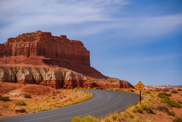 <p>Alpan Esen/Getty Images</p> Road entering Goblin Valley State Park.