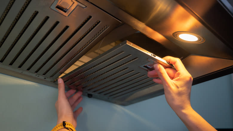 woman cleaning vent hood filters