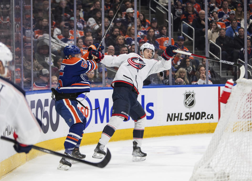 Columbus Blue Jackets' Damon Severson (78) is hit by Edmonton Oilers' Dylan Holloway (55) during the second period of an NHL hockey game Tuesday, Jan. 23, 2024, in Edmonton, Alberta. (Amber Bracken/The Canadian Press via AP)