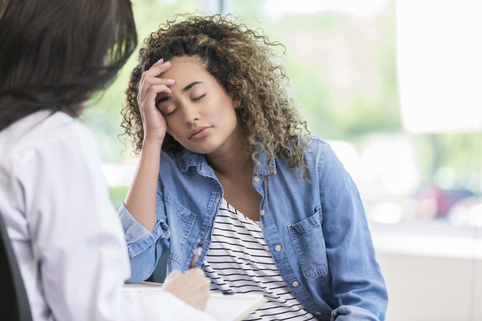 Woman consulting a healthcare professional, appears distressed