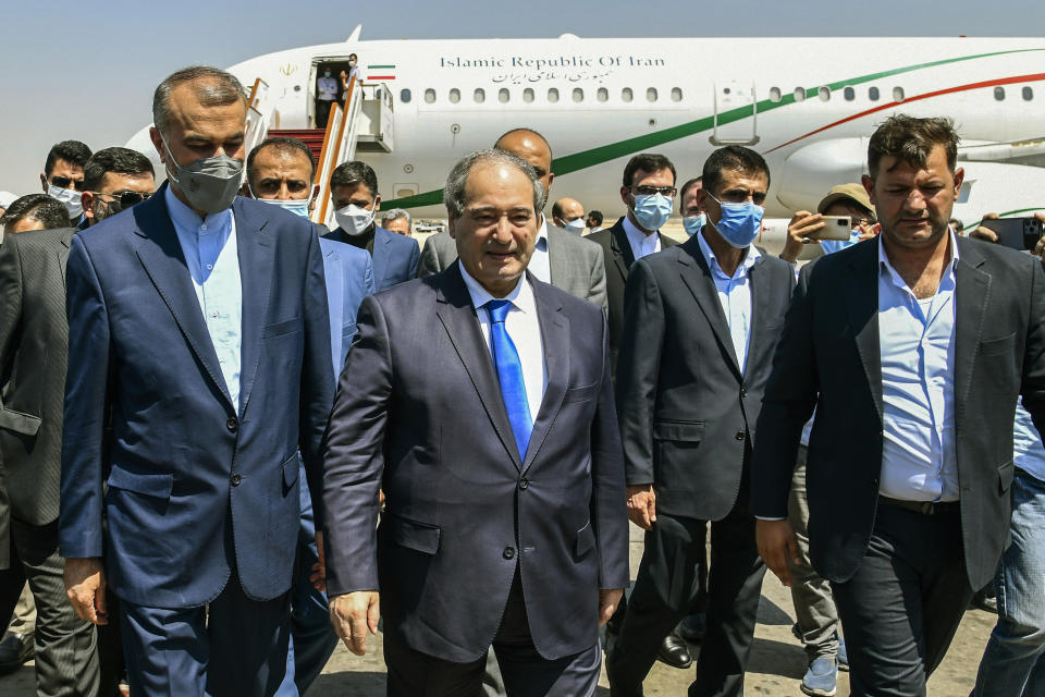 In this photo released by the Syrian official news agency SANA, Syria's Foreign Minister Faisal Mekdad, center left, receives Iran's new Foreign Minister Hossein Amir-Abdollahian, left, in Damascus, Syria, Sunday Aug. 29, 2021. Mekdad said Sunday that the "thunderous defeat" by the United States in Afghanistan will lead to similar defeats for American troops in Syria and other parts of the world. (SANA via AP)