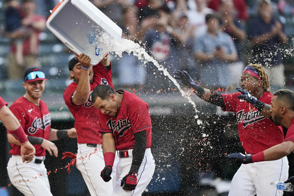 Cleveland Indians teammates douse Cesar Hernandez, center, after he hit the winning two-run home run in the 10th inning of a baseball game against the Minnesota Twins, Saturday, May 22, 2021, in Cleveland. (AP Photo/Tony Dejak)