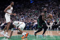 Cleveland Cavaliers guard Darius Garland, left, drops to the floor after being fouled by Boston Celtics guard Jaylen Brown, right, during the first half of Game 5 of an NBA basketball second-round playoff series Wednesday, May 15, 2024, in Boston. (AP Photo/Charles Krupa)