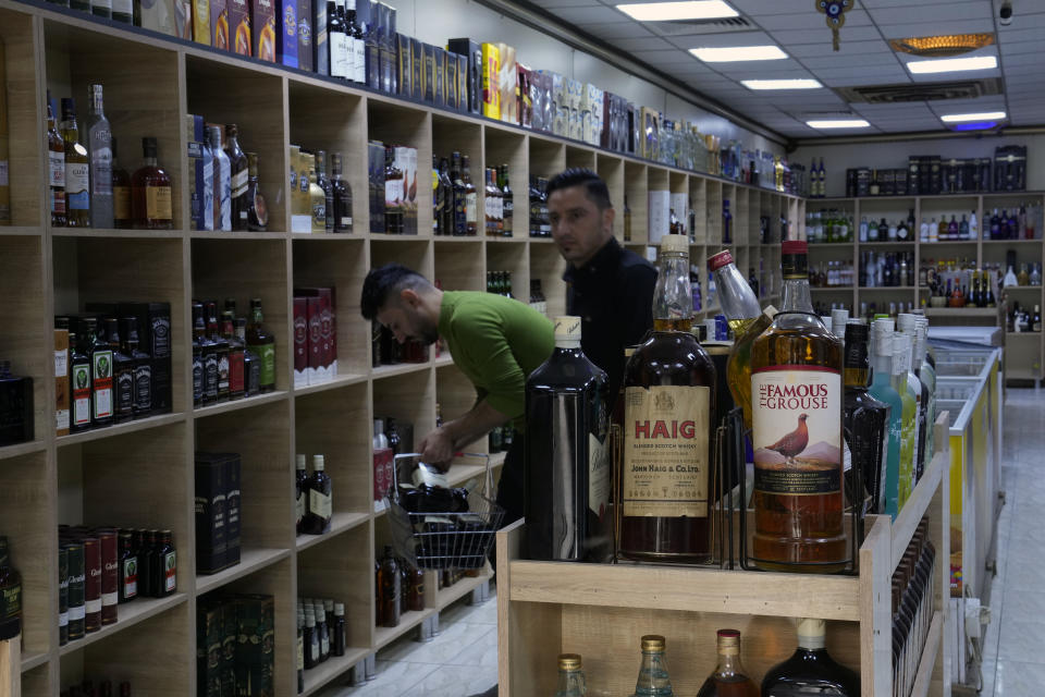 People buy alcohol in a liquor store in Baghdad, Iraq, Thursday, March 9, 2023. The Iraqi government started enforcing a 2016 ban on alcoholic beverages this month, although many liquor shops remained open in Baghdad. (AP Photo/Hadi Mizban)